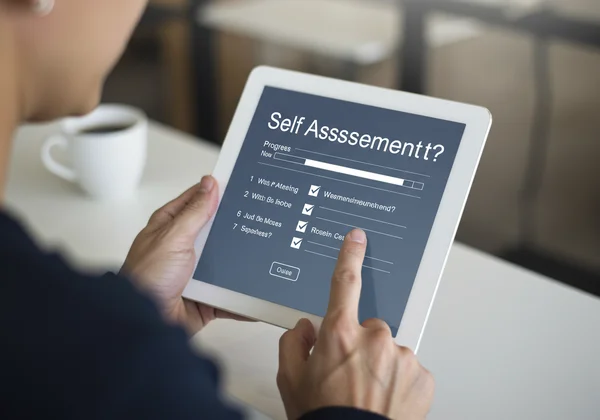 Person taking a self-assessment on a tablet, focusing